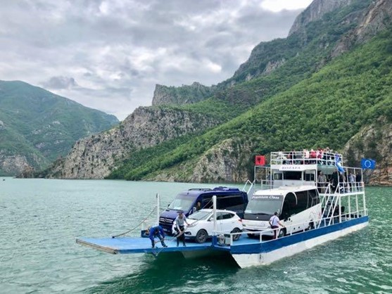 Rozafa ferry operating in Komani Lake with mountain scenery